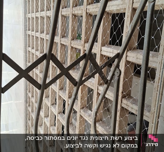 רשת מתכת על חלון למניעת כניסת יונים
